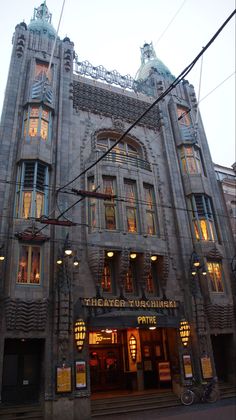 an old building with many windows and lights on the top floor is lit up at night