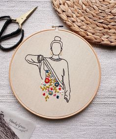 the embroidery is being worked on by someone using scissors and thread to make it look like they are holding something