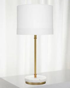 a white and gold lamp sitting on top of a table