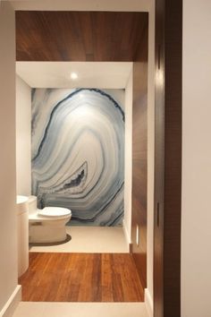 the bathroom is decorated in marble and wood, with an interesting painting on the wall