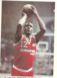 a man holding a basketball in his right hand while wearing a red and white uniform