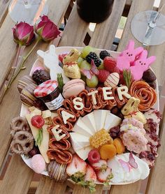 a platter filled with lots of different types of food on top of a wooden table