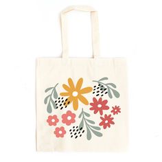 a tote bag with flowers on it sitting on a white surface, in front of a white background