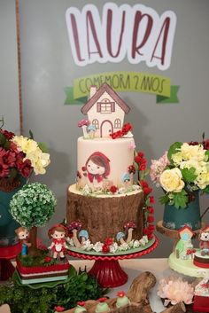 there is a cake on the table with flowers and other items around it that are also decorated