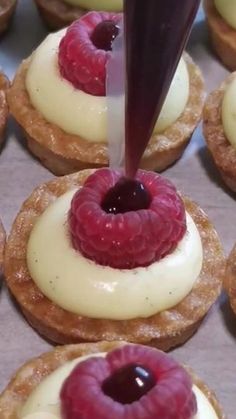 the pastry is being drizzled with icing and raspberries