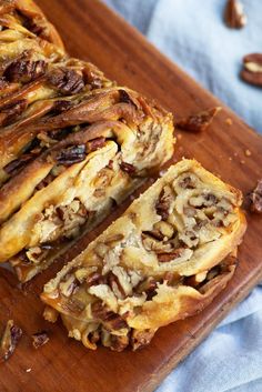 a wooden cutting board topped with slices of pecan and raisins dessert bread