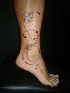 a woman's foot with a flower tattoo on her left side and the bottom part of her leg