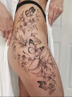 a woman's thigh with flowers and butterflies on it