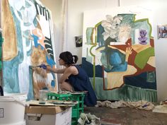 a woman is painting in an art studio