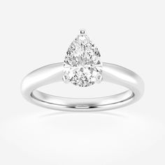 a pear shaped diamond engagement ring on a white background, with the center stone set in 18k white gold