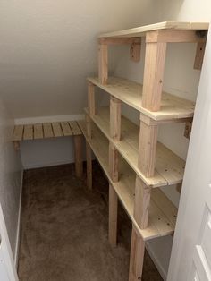 a room with some shelves made out of wooden planks and no one is in it