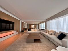 a living room filled with lots of furniture and a flat screen tv mounted on the wall