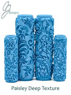 four blue vases with designs on them in the shape of flowers and leaves, all lined up against a white background