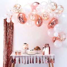 a table topped with lots of balloons and confetti on top of white tables