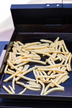 french fries are being cooked on an outdoor grill