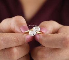 a woman holding two diamond rings in her hands