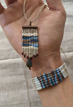 a person's hand holding two bracelets with beads and bead on them