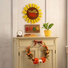 a white cabinet with a wreath on top of it