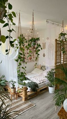 a room filled with lots of plants next to a bed