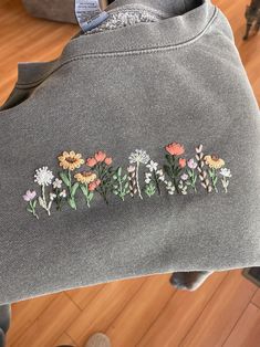 embroidered flowers are on the back of a sweatshirt