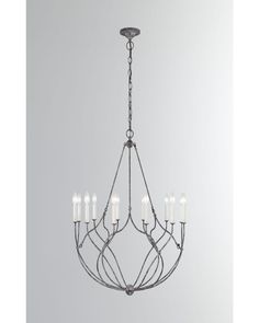 an iron chandelier with eight candles hanging from the center, on a gray background