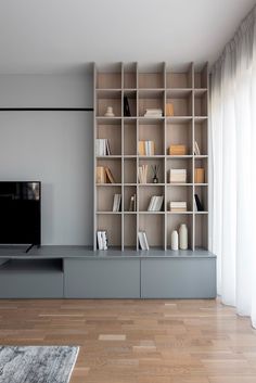 a living room filled with furniture and a flat screen tv on top of a wooden shelf