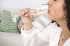 a woman is drinking from a wine glass