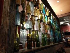 there are many different colored glass bottles on the wall