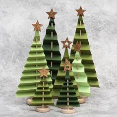 three green christmas trees with gold stars on them