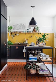 a kitchen with yellow walls, black cabinets and an orange tiled floor is seen in this image