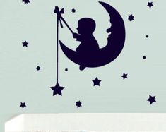 a child's room with a wall decal that has the moon and stars on it