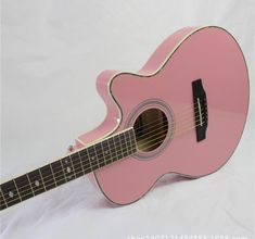 a pink ukulele sitting on top of a white sheet