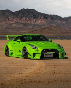 a green sports car parked in the desert