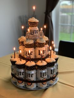 a cake made out of beer cans with lit candles
