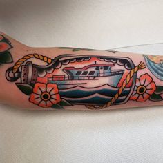 a boat with flowers on it and a rope around the wrist is shown in this tattoo design