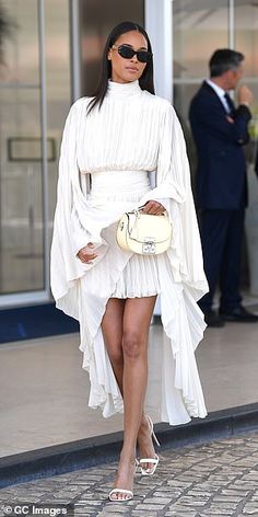 Cindy Bruna flaunts her legs in a glamorous white pleated mini dress