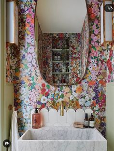 a bathroom with floral wallpaper and marble sink