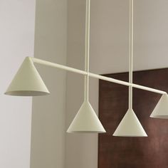 three white lights hanging from a ceiling in a room