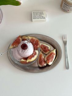 a plate that has some fruit on it with a fork and spoon next to it