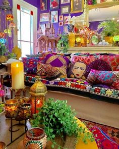 a living room filled with lots of colorful furniture and decorating items on top of a wooden table