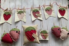 several strawberry shaped pillows hanging on clothes pins