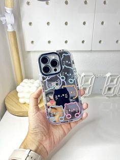 a person holding an iphone case with cats on it