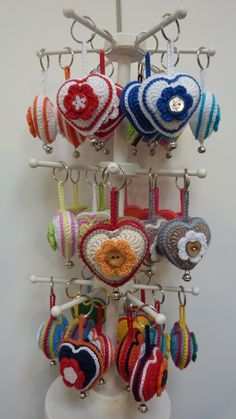 several heart shaped ornaments hanging from hooks on a wall