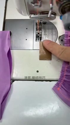 someone is using a sewing machine to sew purple material on the tablecloths