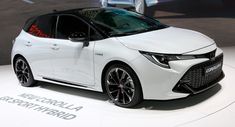 a white car is on display at an auto show