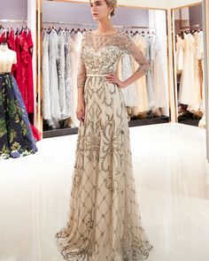 a woman standing in front of a rack of dresses at a bridal fashion show