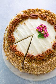 a cake with white frosting and pecans on top is cut in half to look like a pie