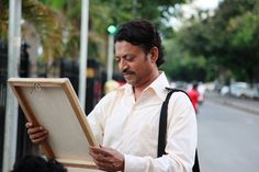 a man holding an open box on the street