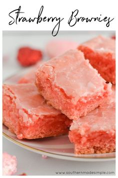 some pink frosted squares on a plate with raspberries in the back ground