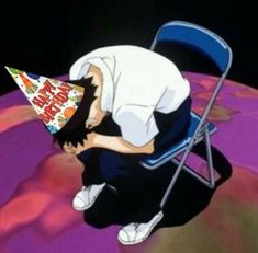 a man sitting in a chair with a birthday hat on